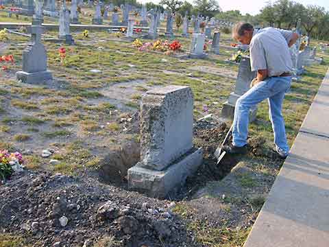 Working to clean and reset headstone